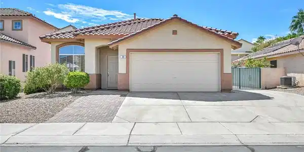 Image 2: A classic stucco exterior features a tiled roof an