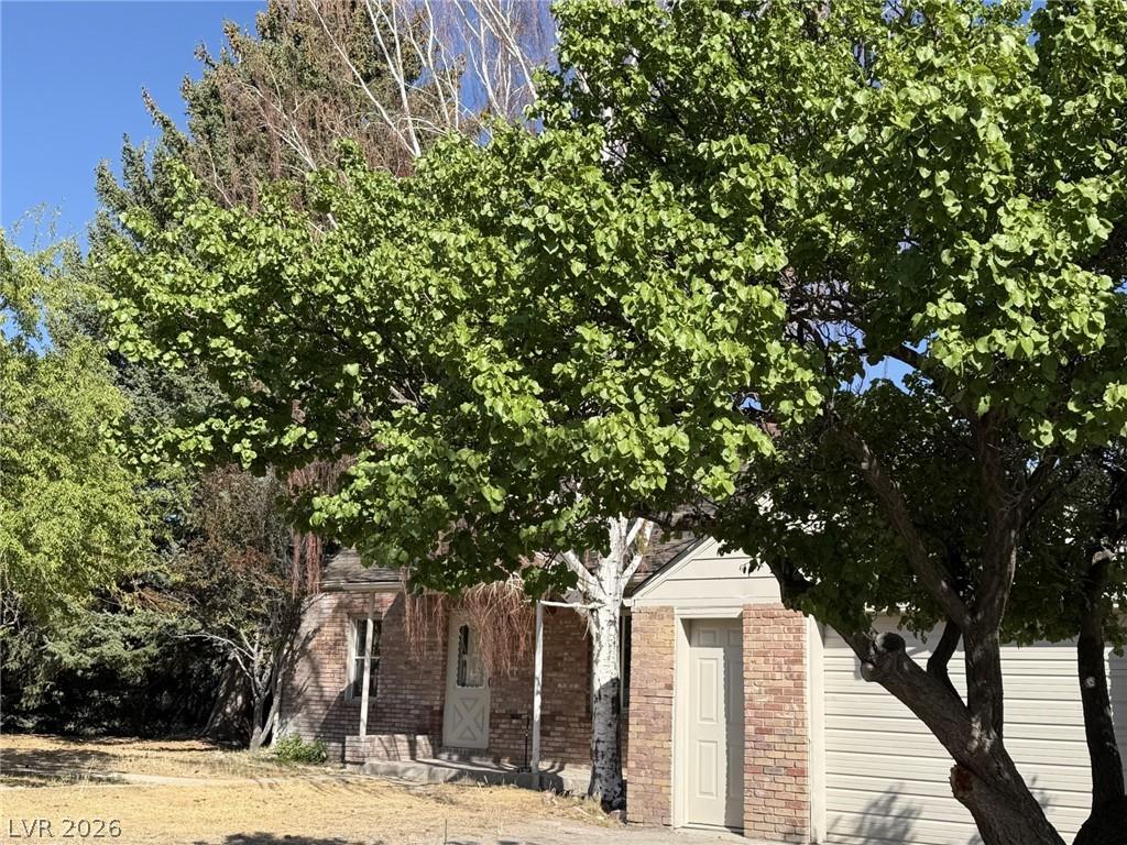Image 2: Mature trees and brick accents adorn the charming