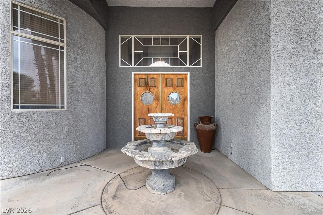 Image 4: Doorway to property with stucco siding and a patio