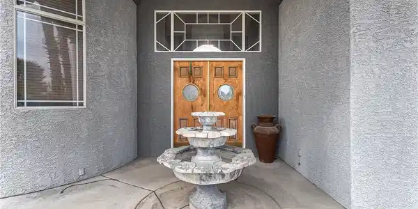 Image 4: Doorway to property with stucco siding and a patio