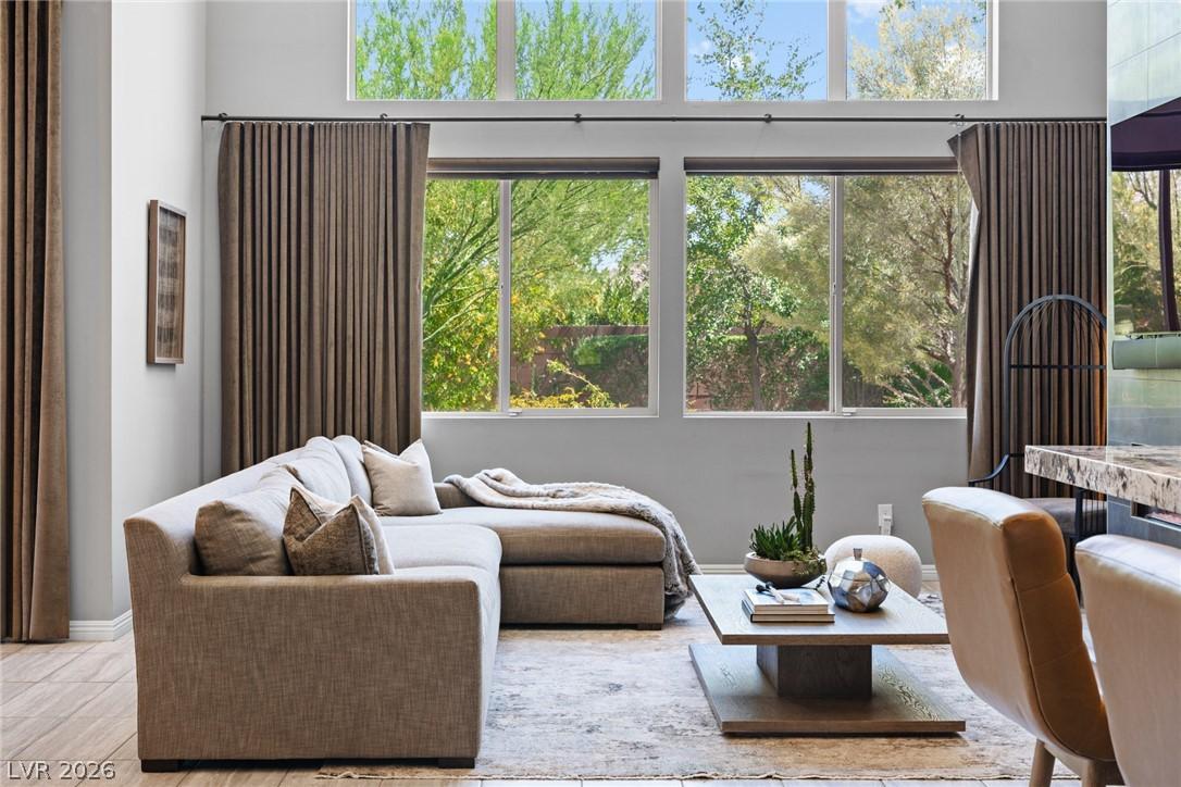 Image 4: A welcoming living area boasts soaring windows, fr