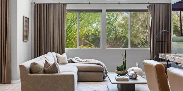 Image 4: A welcoming living area boasts soaring windows, fr