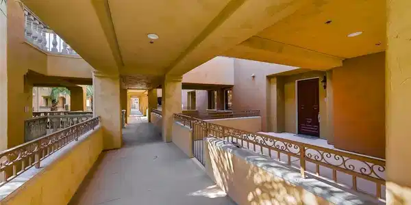 Image 2: A long, covered outdoor walkway leads to private e