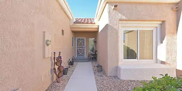 Image 2: A concrete walkway leads to the private gated entr