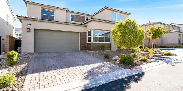 Image 2: A paved driveway leads to a modern two-story home