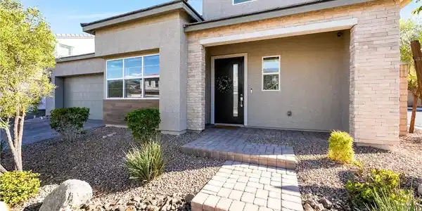 Image 4: A welcoming stone-accented entryway leads past low
