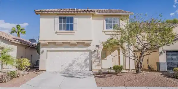 Image 2: A classic two-story exterior features stucco finis