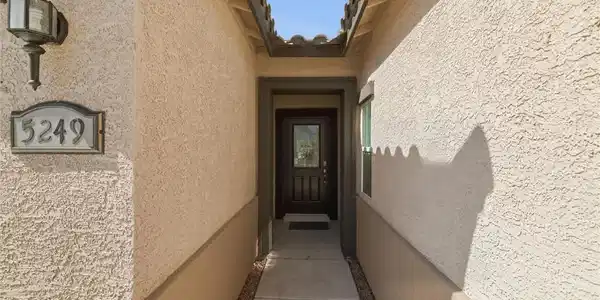 Image 3: A welcoming entryway with a dark wood door and dec
