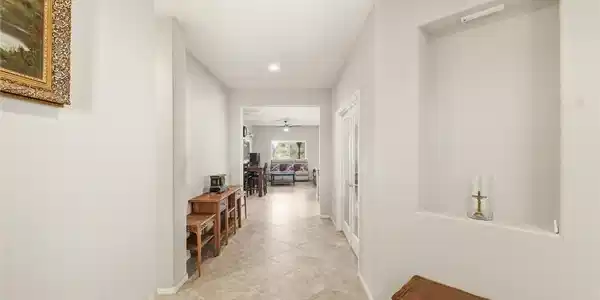 Image 4: This interior hallway features neutral-toned tile