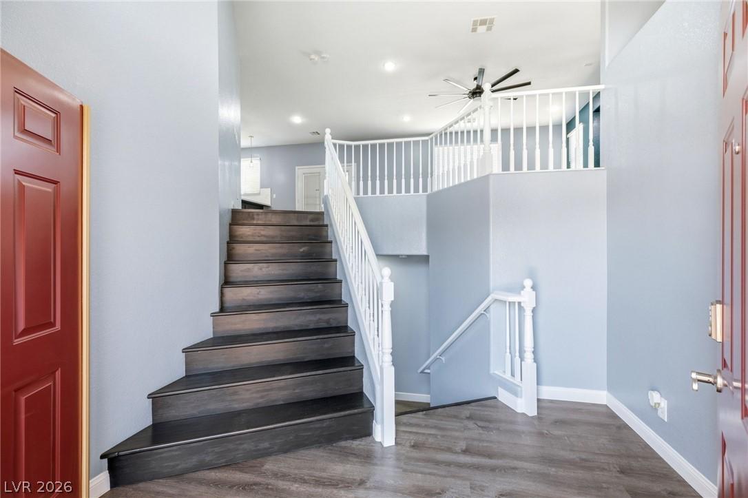 Image 2: This inviting entry features a graceful staircase