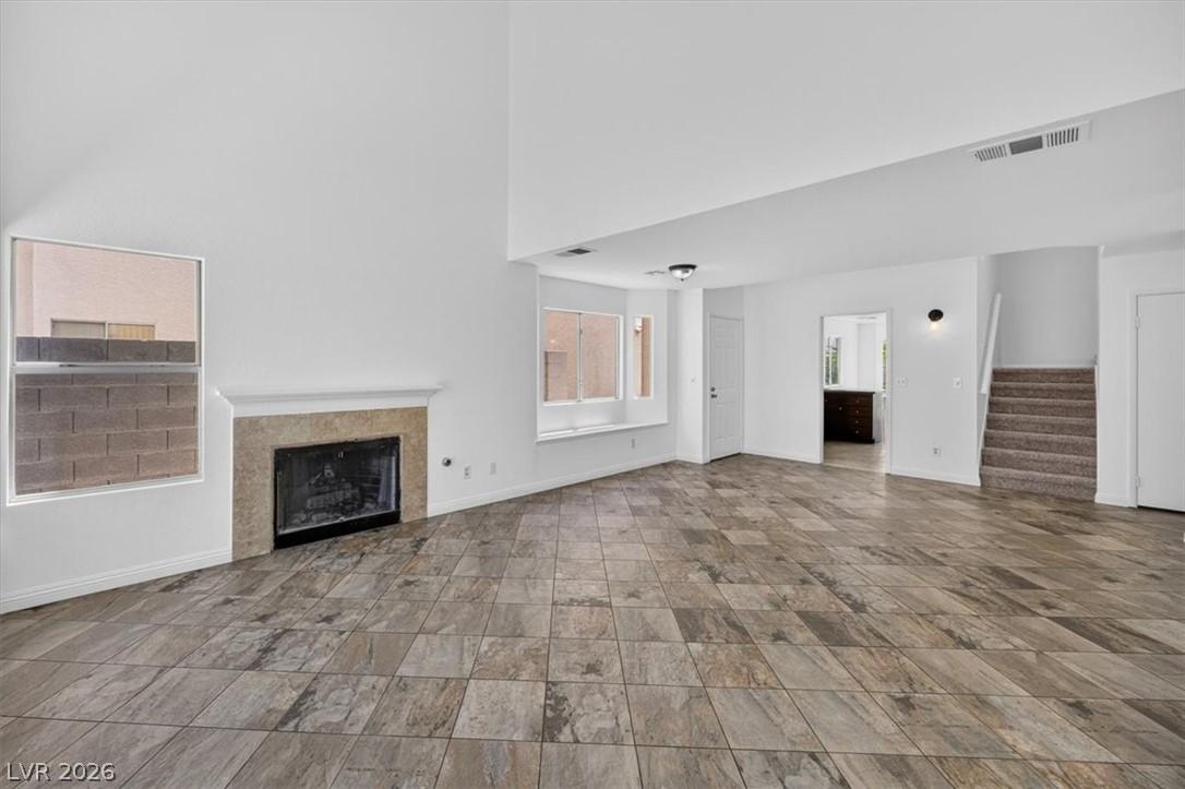Image 3: A spacious living area featuring high ceilings, a