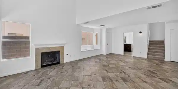 Image 3: A spacious living area featuring high ceilings, a