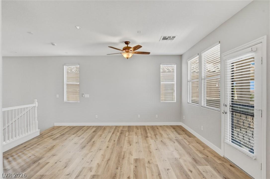 Image 2: A well-lit living area features hardwood flooring