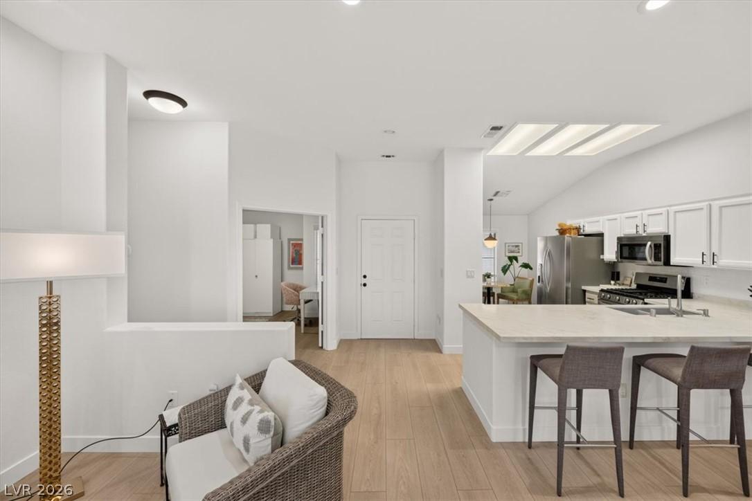 Image 3: Blonde wood flooring unifies the open-concept livi