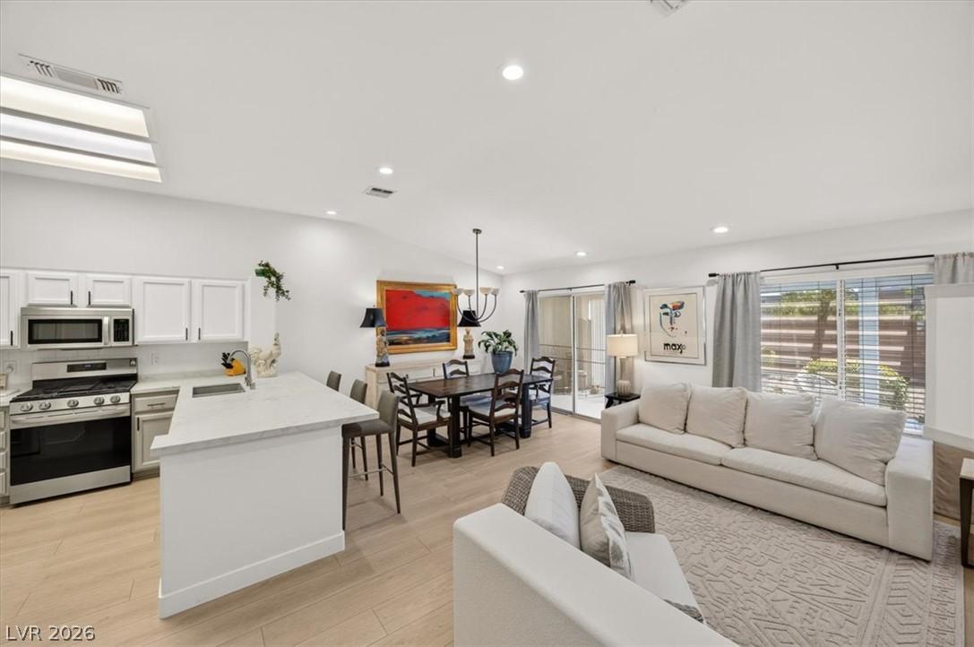 Image 4: An open-concept living area boasts a modern kitche