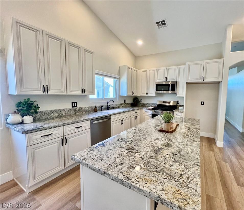 Image 1: A well-lit kitchen featuring an expansive granite