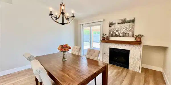 Image 2: A well-lit dining area features a warm wooden tabl