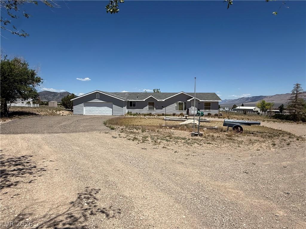 Image 1: A welcoming home with a two-car garage, set agains