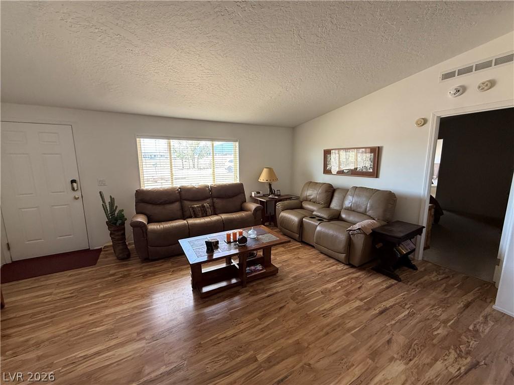 Image 4: A welcoming living area boasts durable hardwood-st
