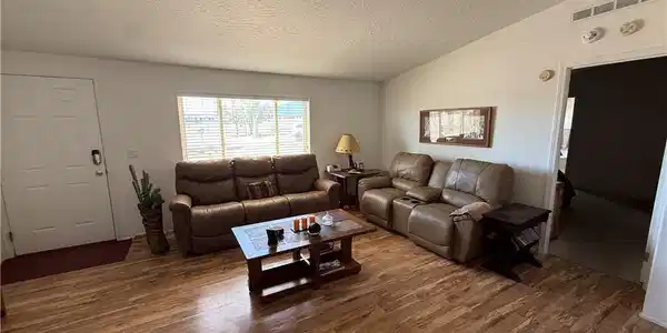 Image 4: A welcoming living area boasts durable hardwood-st