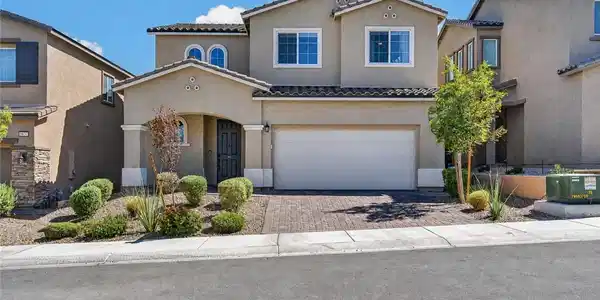 Image 3: A well-kept facade showcases a paver driveway and