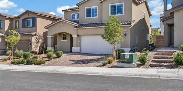 Image 4: A welcoming front exterior featuring a paver drive