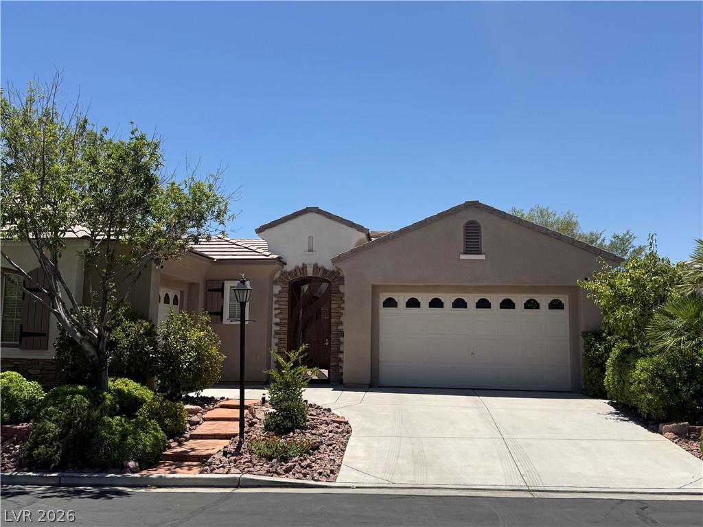 Image 1: A well-maintained stucco home offers a brick archw