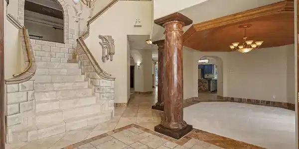 Image 4: A grand entrance welcomes with an ornate staircase