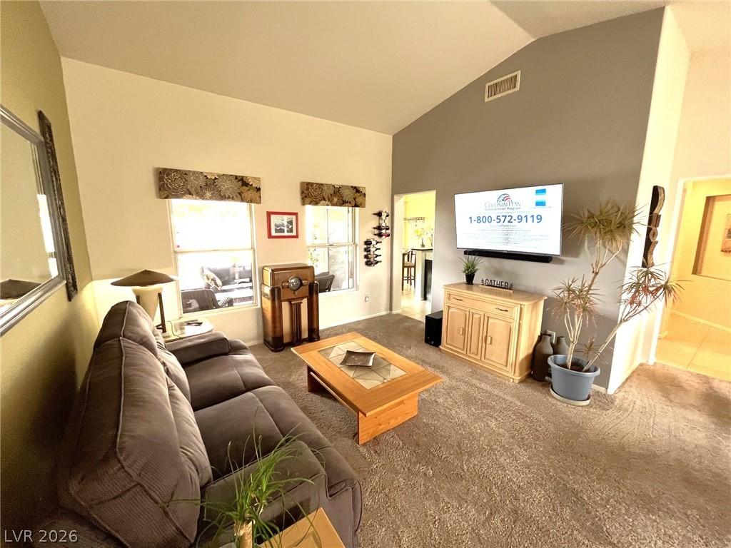 Image 2: A welcoming living room features vaulted ceilings