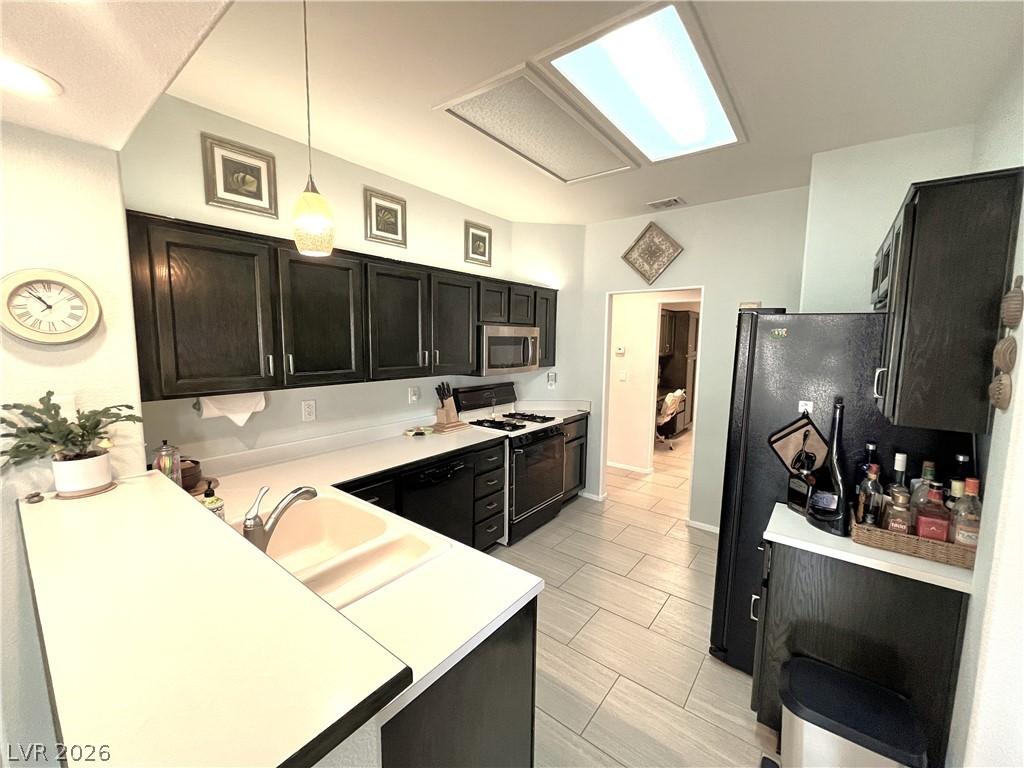 Image 4: A well-lit kitchen featuring rich cabinetry, clean