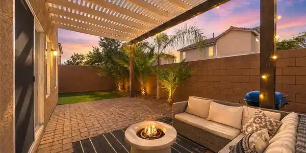 Image 4: An inviting backyard patio features a pergola, pav