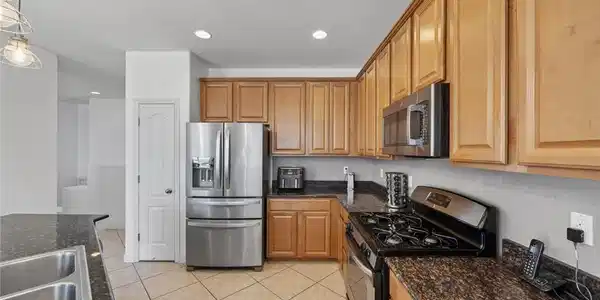 Image 3: This spacious kitchen features ample cabinetry, mo