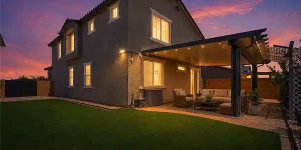 Image 3: An inviting covered patio and lush lawn define the