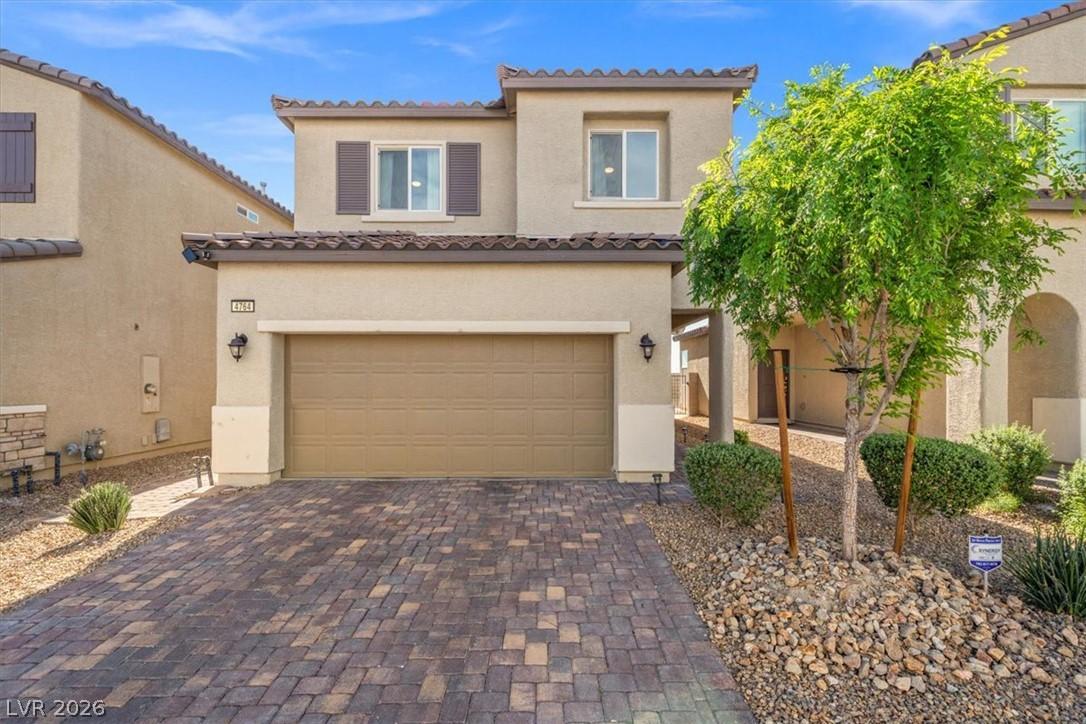 Image 2: A neatly paved driveway leads to this charming two