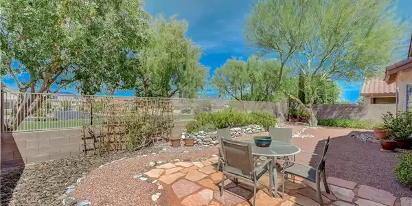 Image 4: Mature trees frame a flagstone-paved patio space w
