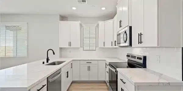 Image 4: Crisp white cabinetry paired with sleek stone coun