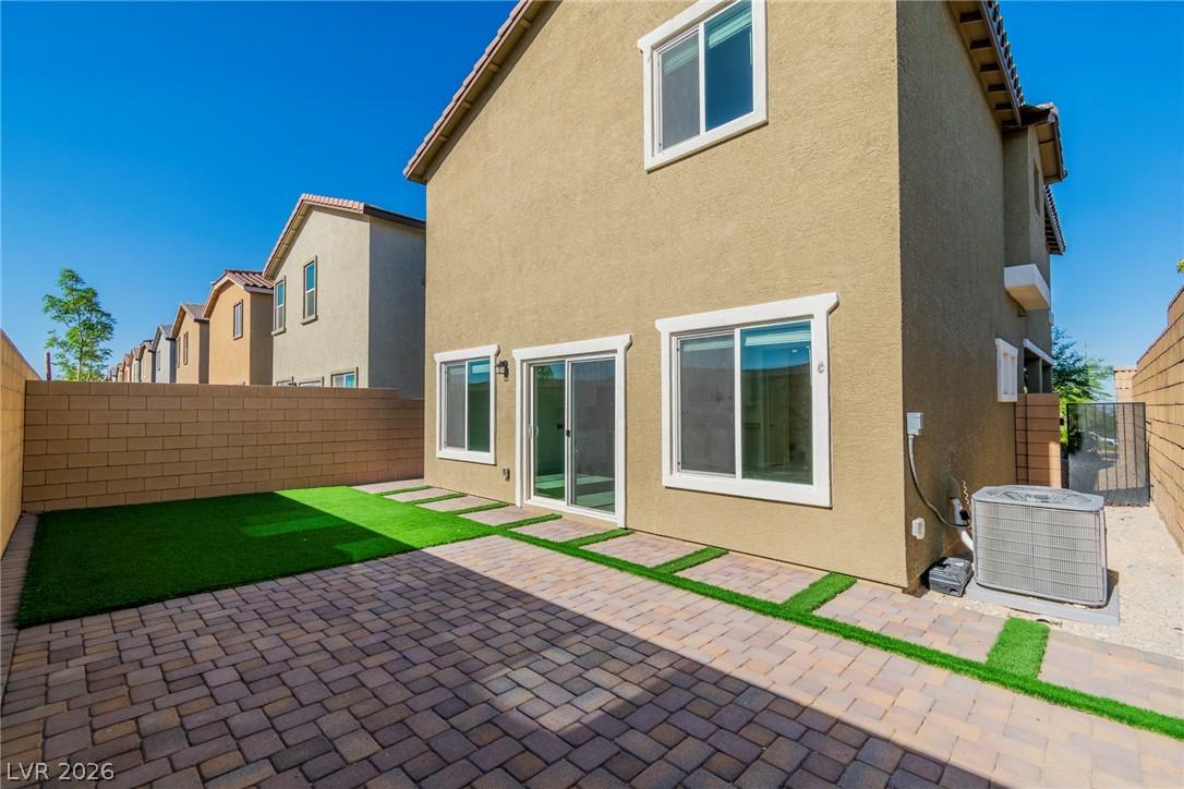 Image 4: A private yard with artificial turf and paver ston