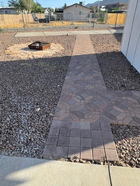 Image 4: A charming paver pathway leads to a cozy outdoor f