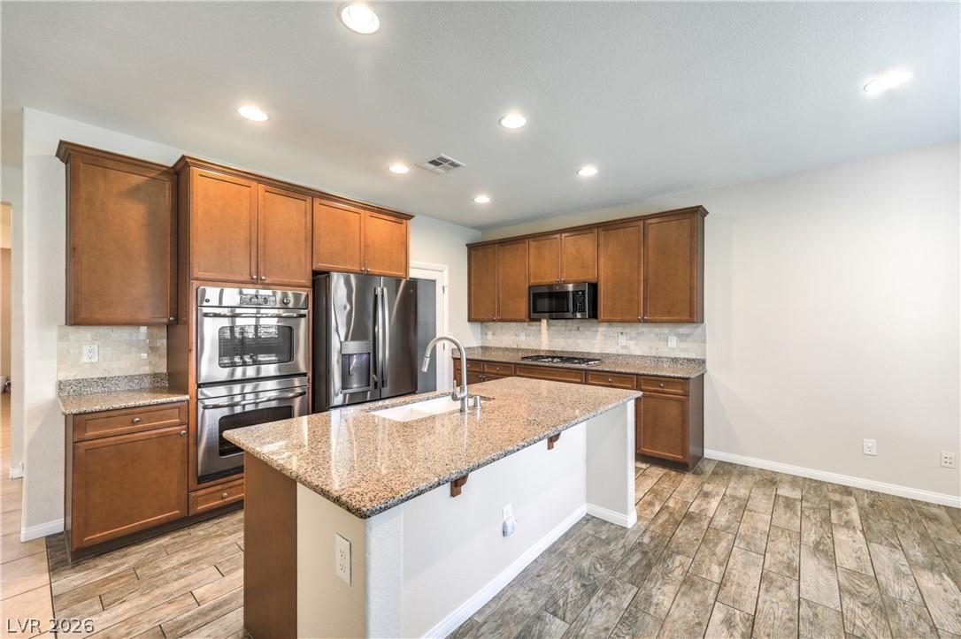 Image 4: A contemporary kitchen features rich cabinetry, gr