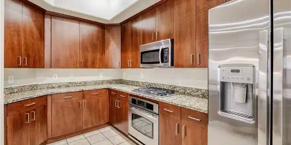 Image 4: This kitchen features rich wood cabinetry and ampl
