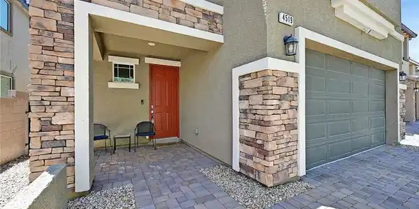 Image 2: A welcoming entry features a rich terracotta door,