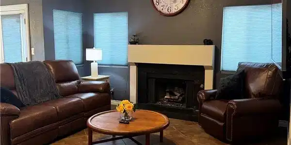 Image 2: A well-lit living space features a cozy fireplace,