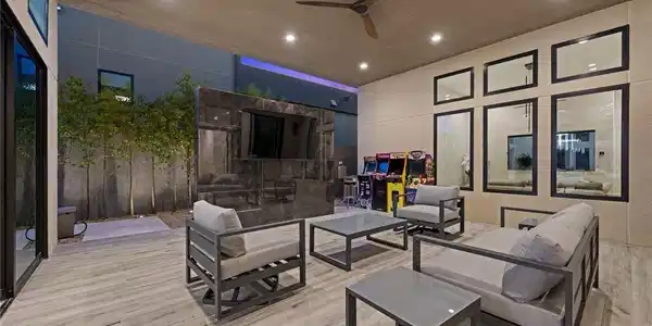 Image 4: An inviting covered patio features modern wood-loo