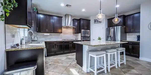 Image 4: Rich dark cabinetry pairs beautifully with stone c