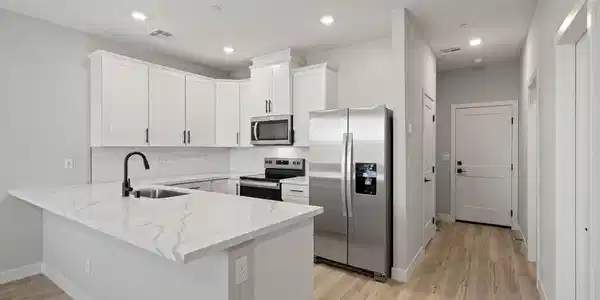 Image 3: This sleek kitchen features clean lines and modern