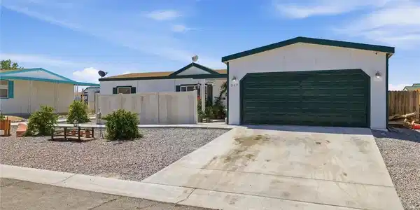 Image 2: A modest residence features a detached garage and
