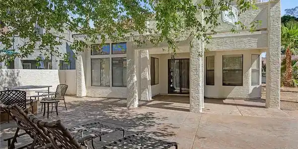 Image 4: A spacious concrete patio awaits outdoor leisure,