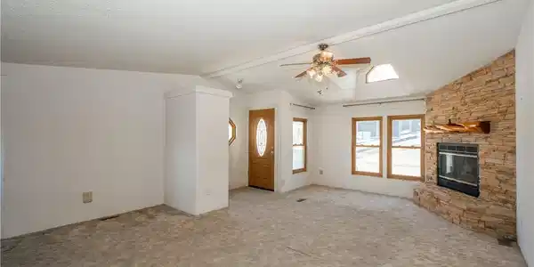 Image 4: A cozy living space features a stone fireplace, sk