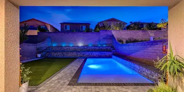 Image 2: An inviting swimming pool and brick patio create a