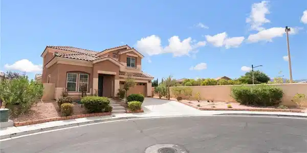 Image 2: A classic stucco exterior is accented by tile roof